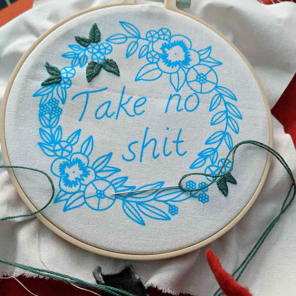 Blue ink pattern on a cloth with the phrase "Take no shit" in the center.